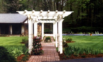 Garden pergola with flowers and brick path