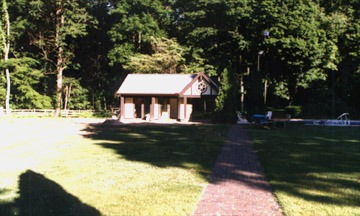 Small house surrounded by trees and grass