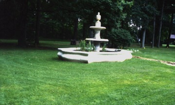 Garden fountain surrounded by lush green grass.