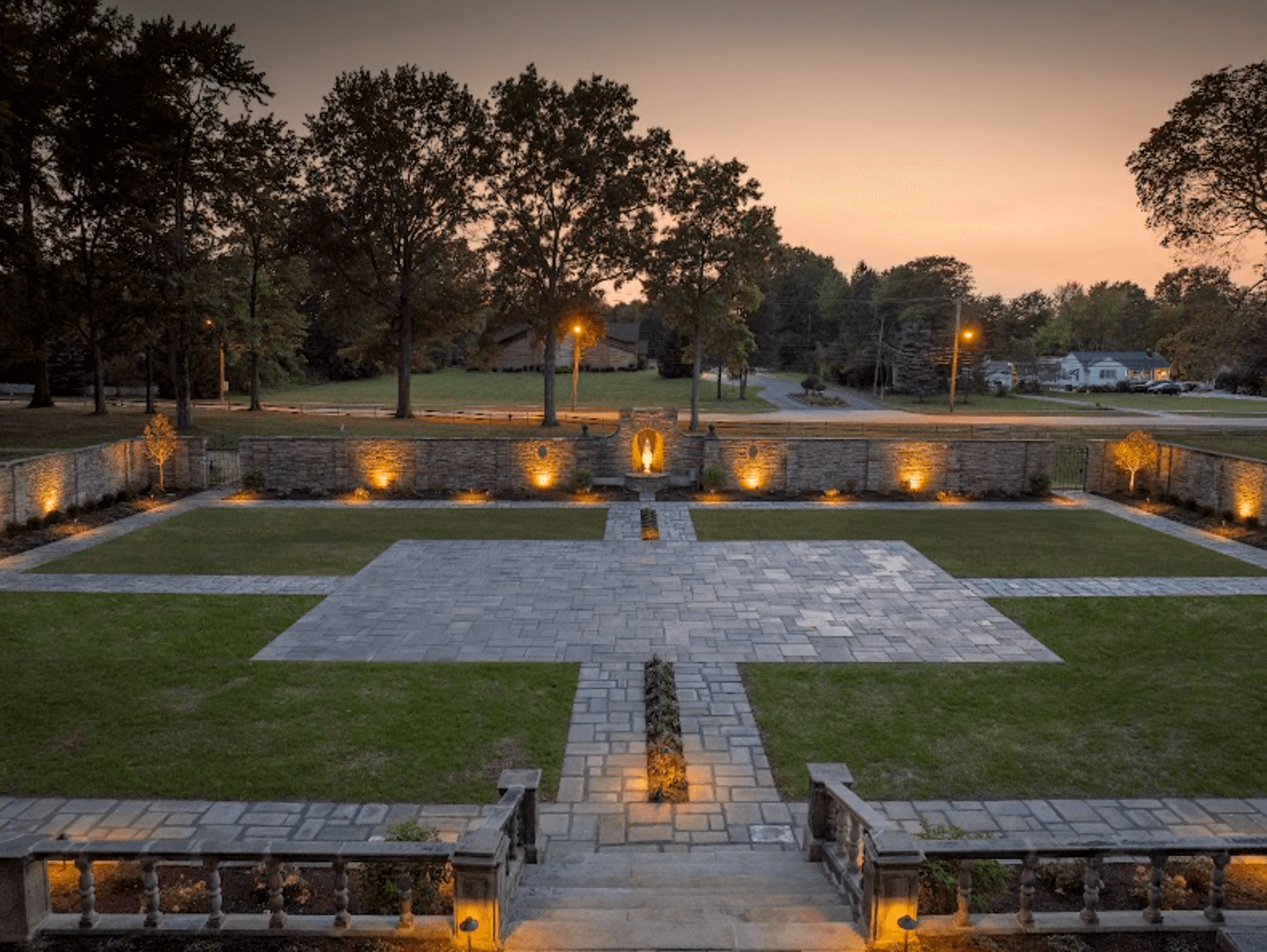 Stone patio and garden with ambient evening lighting.