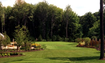 Manicured golf course fairway surrounded by trees.