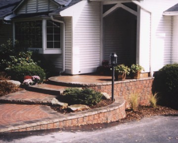 Brick walkway and steps leading to white house entrance.