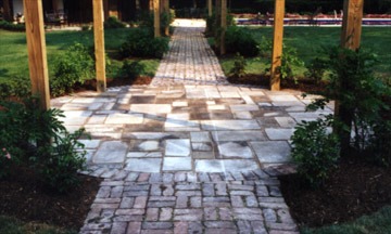 Brick and stone path through garden arbor.