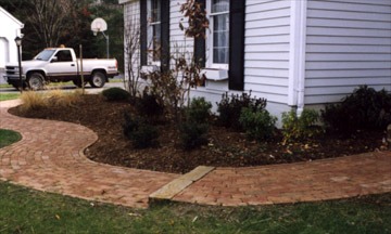 Brick pathway near house with truck in background