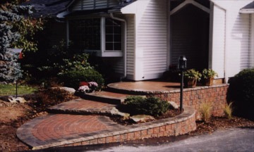 Brick walkway and porch entrance with landscaping
