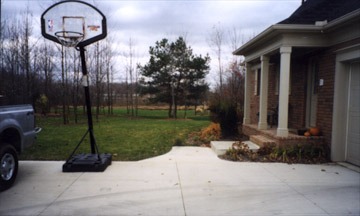 Driveway basketball hoop beside suburban house