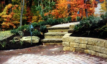 Stone garden pathway with autumn foliage background.