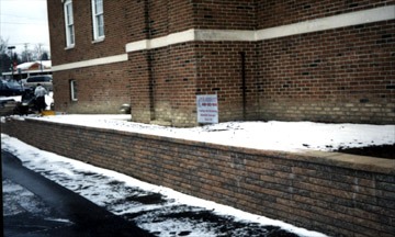 Snowy brick building with retaining wall