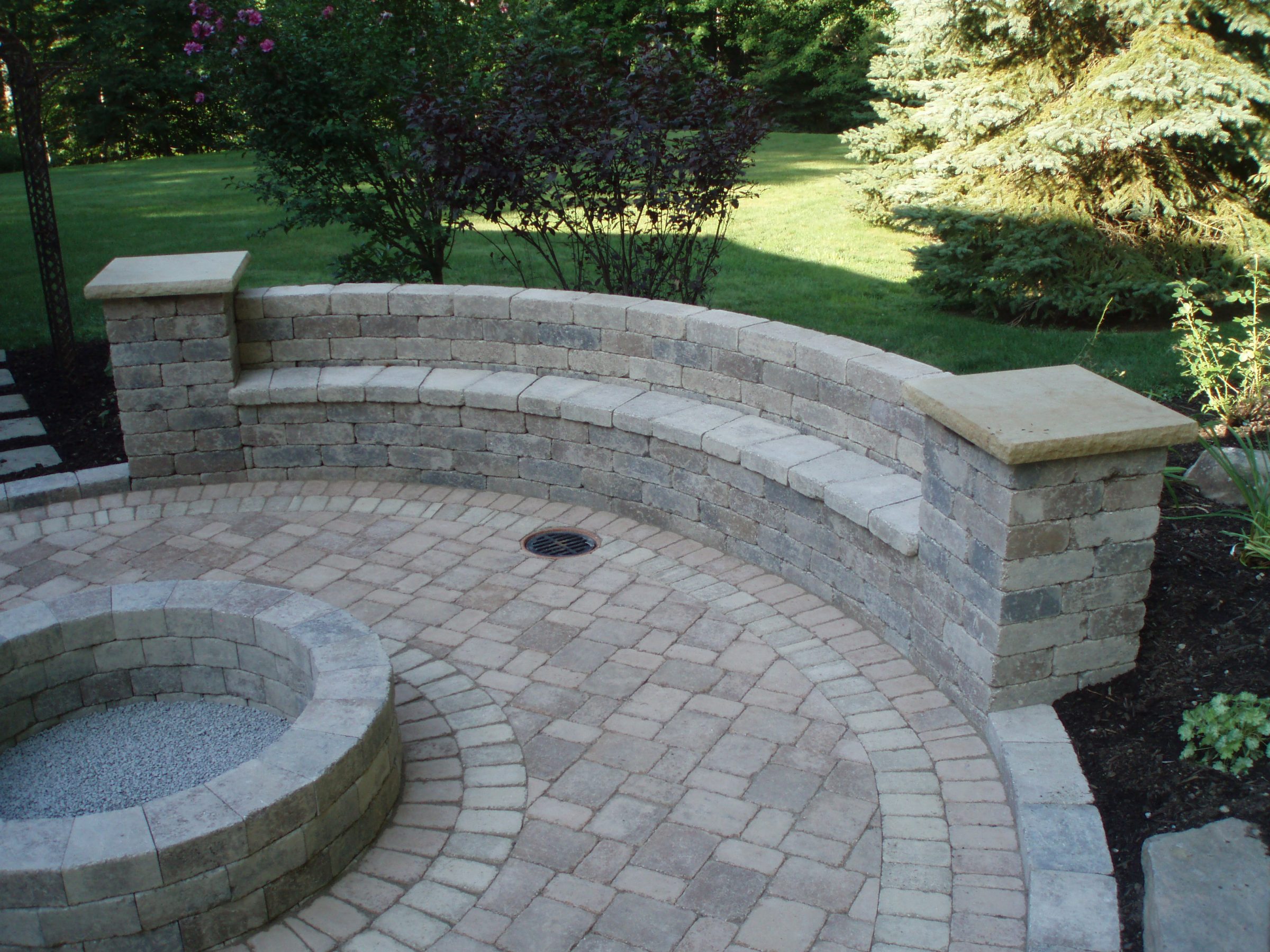Stone patio with curved bench and firepit