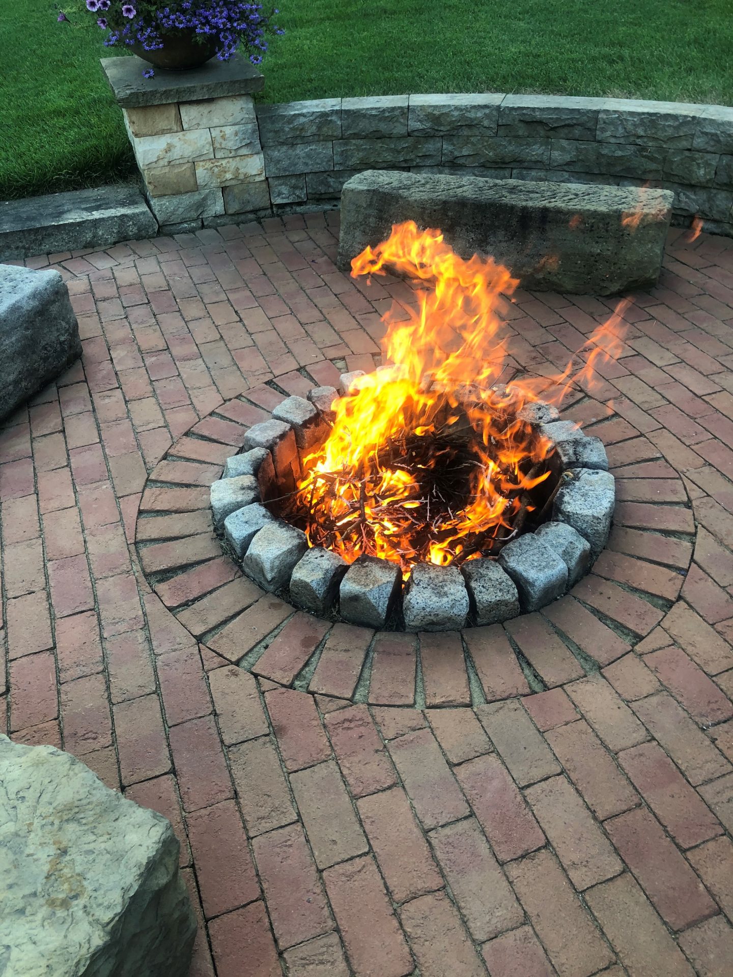 Outdoor fire pit with vibrant flames on patio.