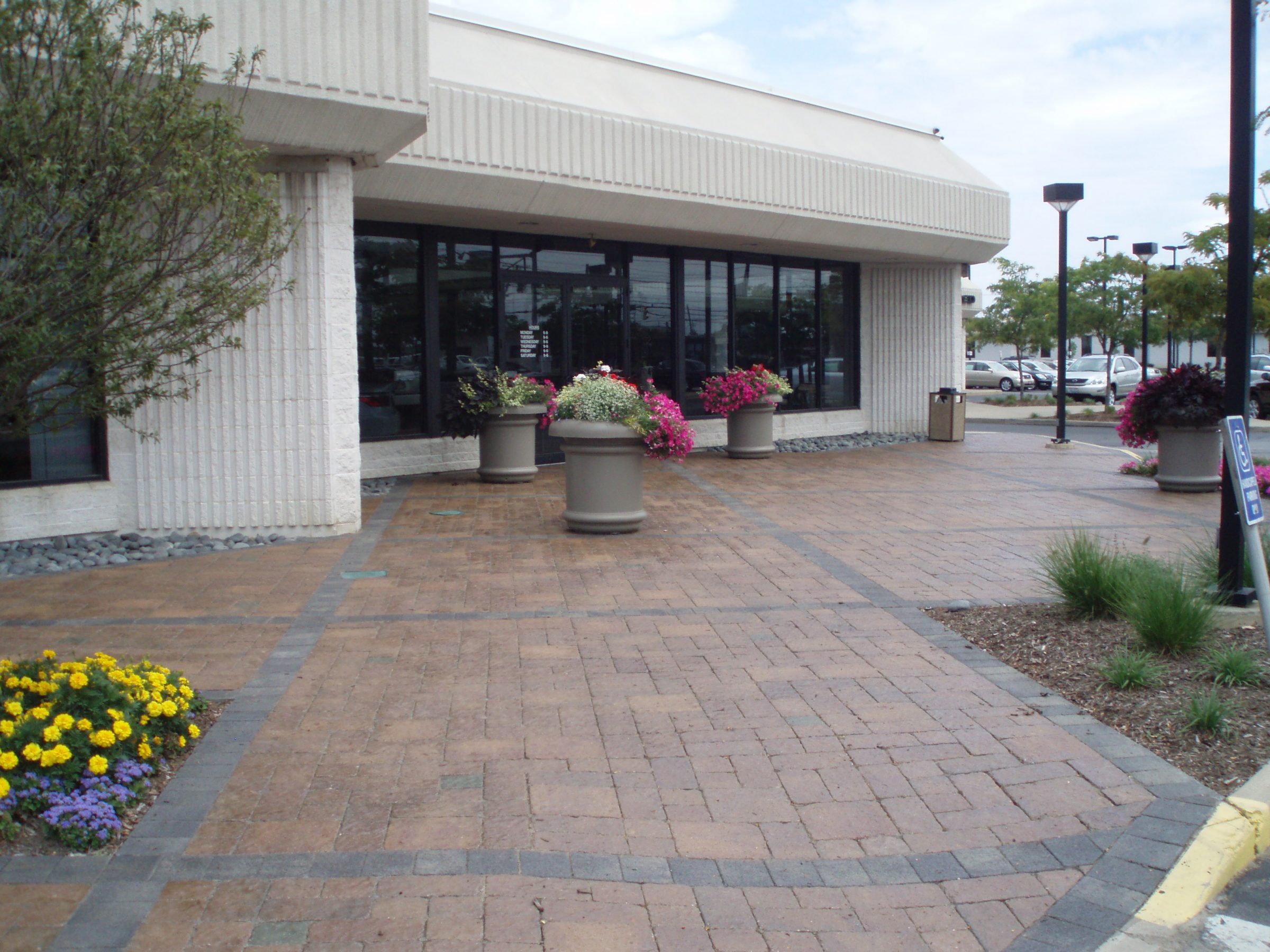 Entrance with brick walkway and potted flowers