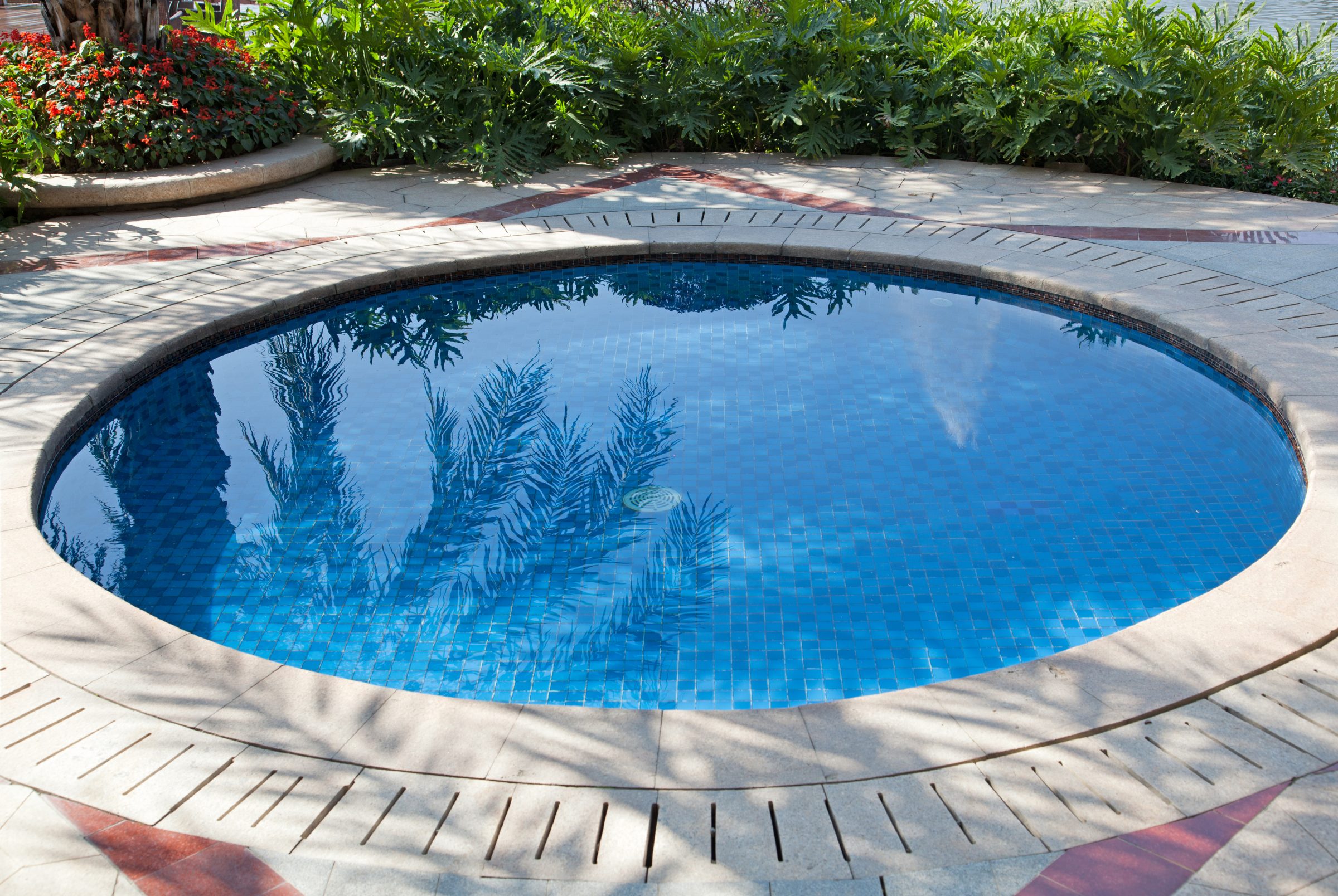 A round, blue tiled swimming pool.