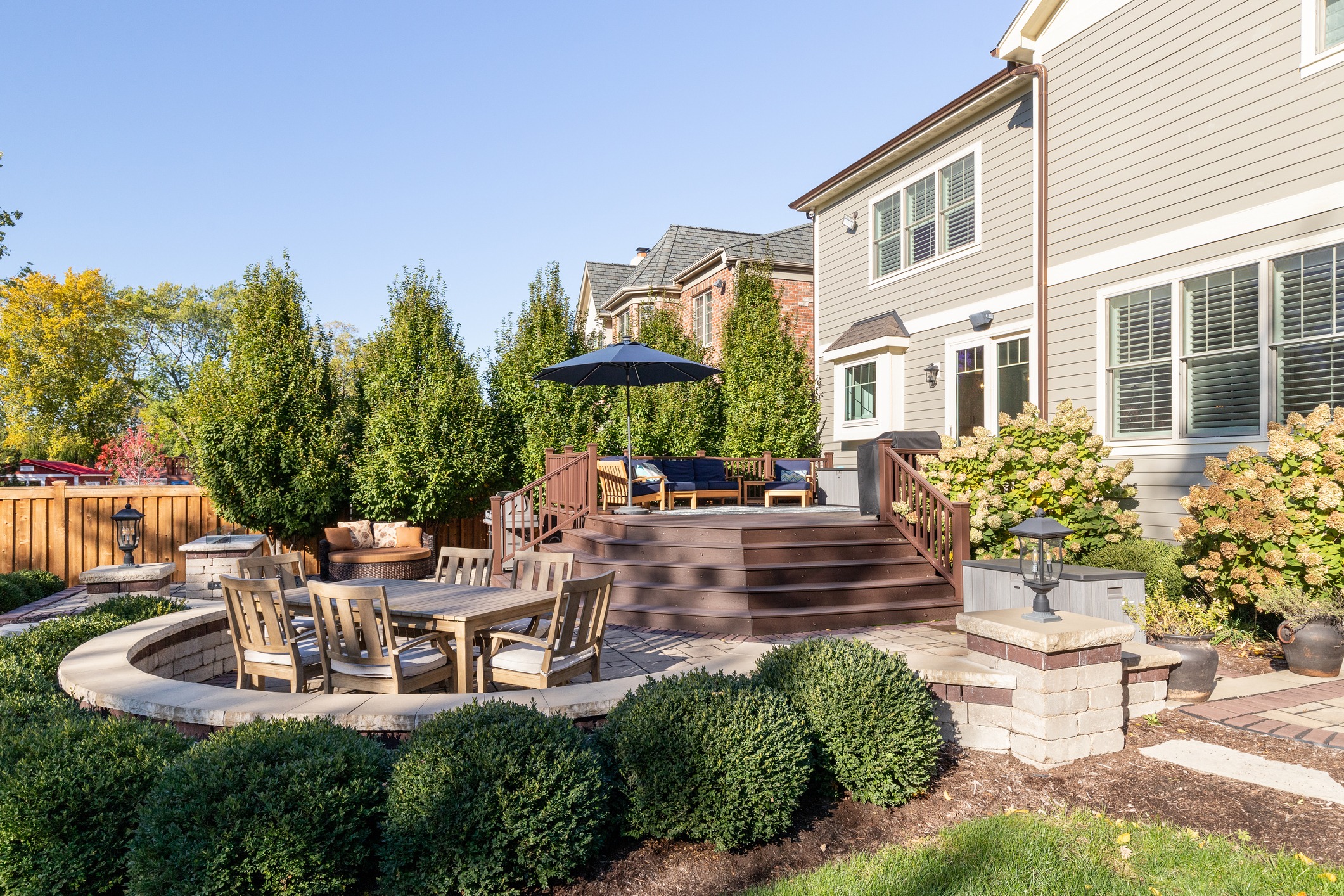 Spacious backyard patio with seating and greenery.