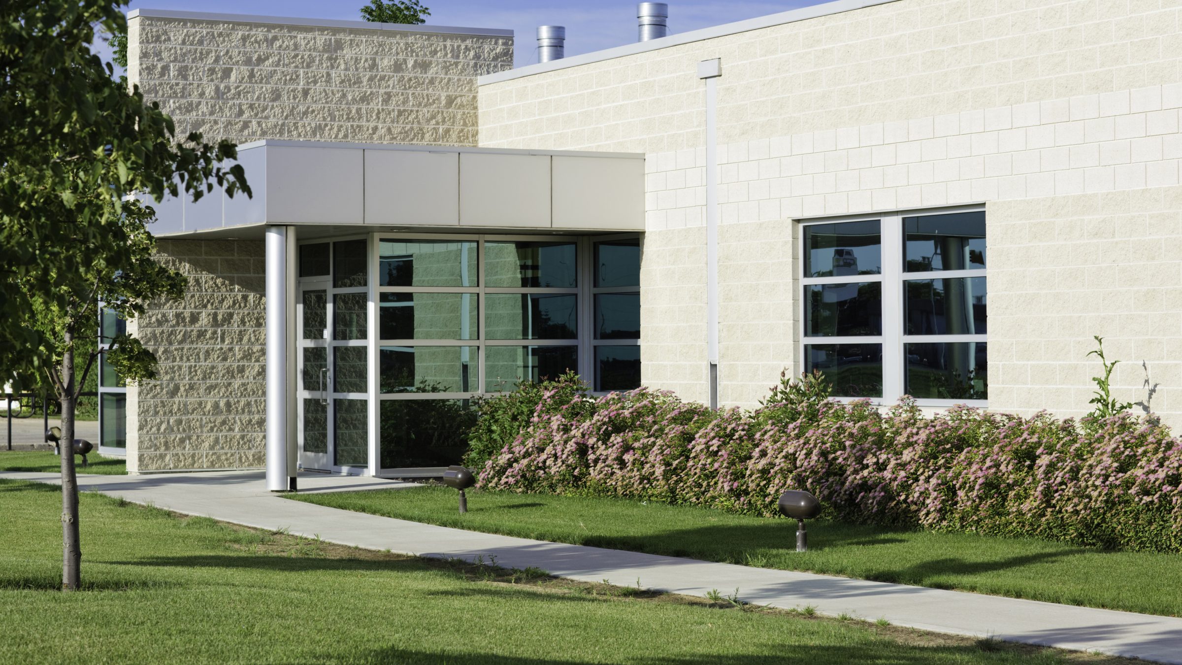 Modern building facade with large windows and landscaping