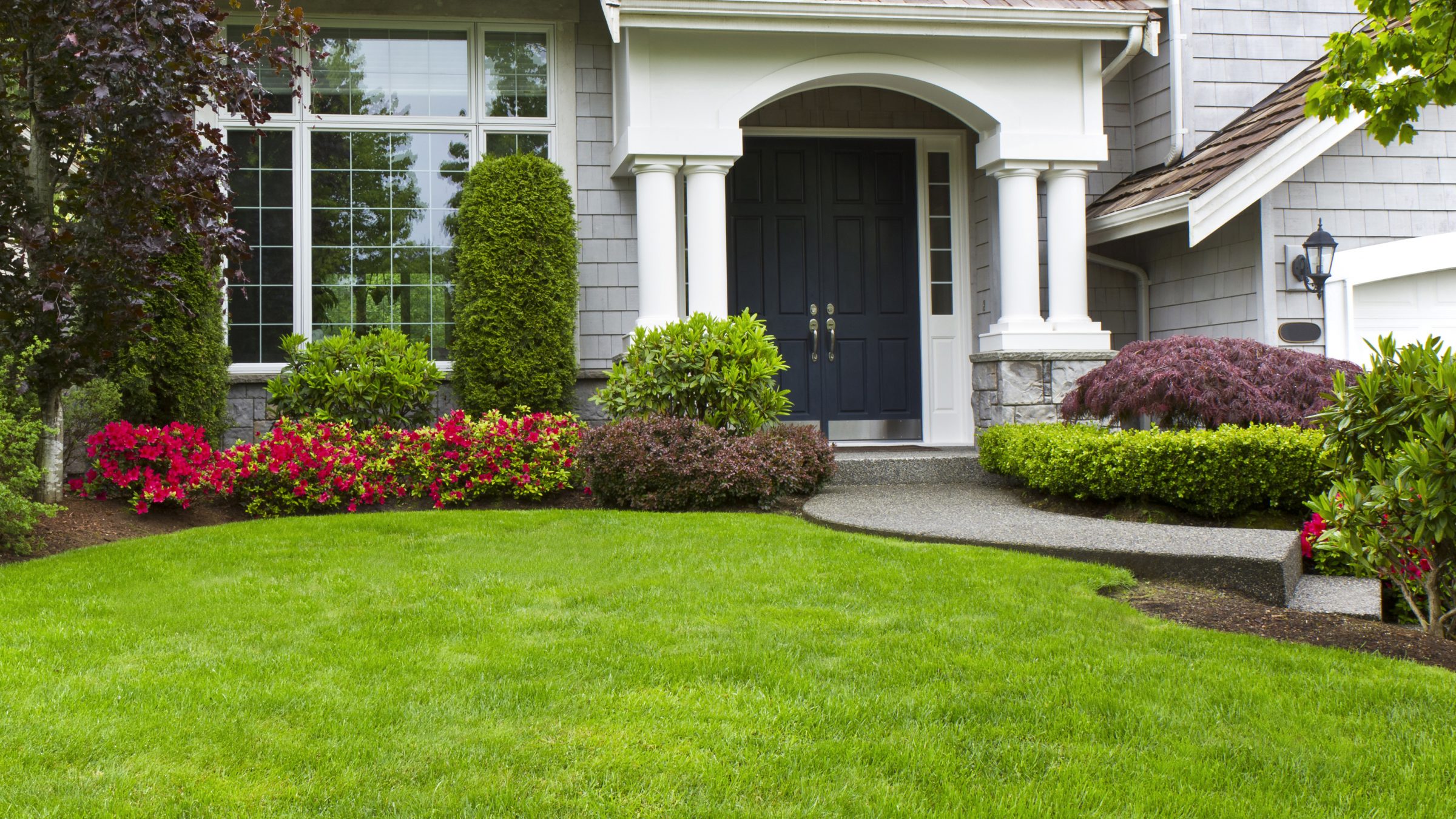 Beautiful house with manicured lawn and garden