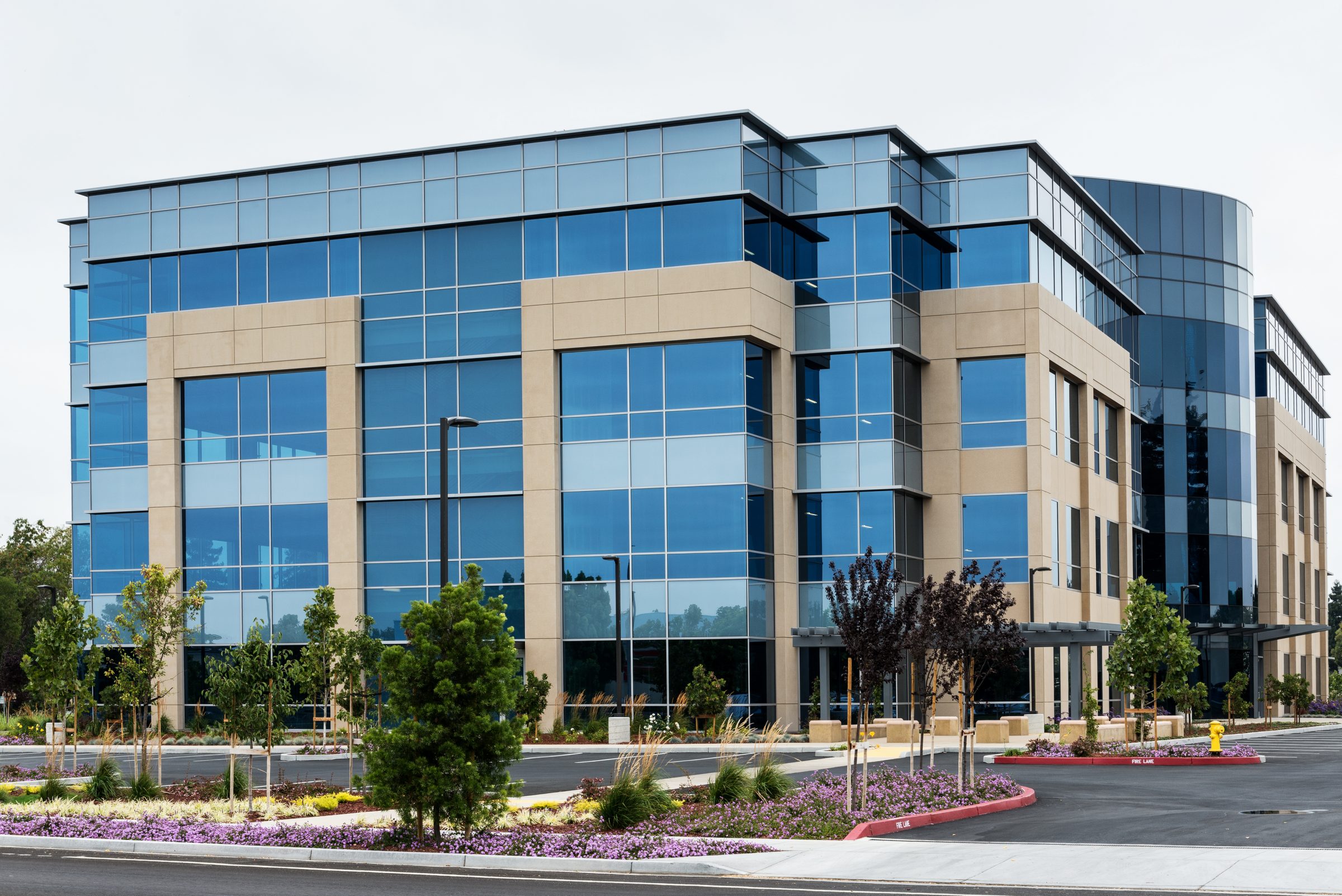Modern office building with glass windows and landscaping.