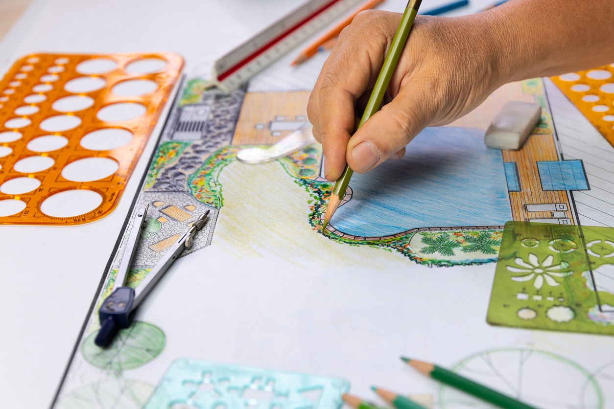 Hand drawing landscape design plan with tools.