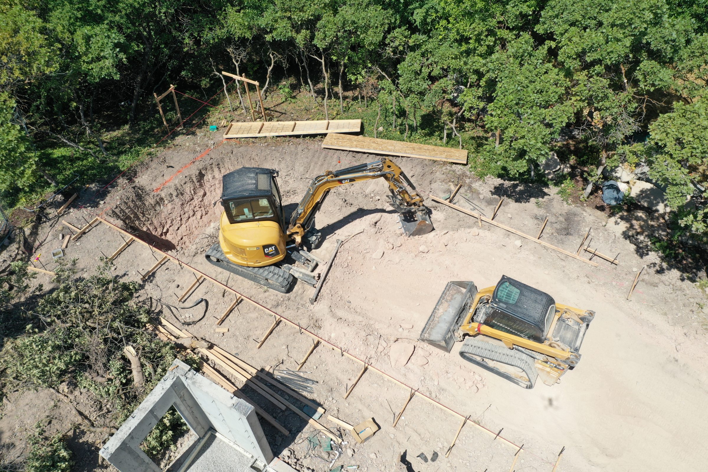 Excavators digging a foundation at construction site.